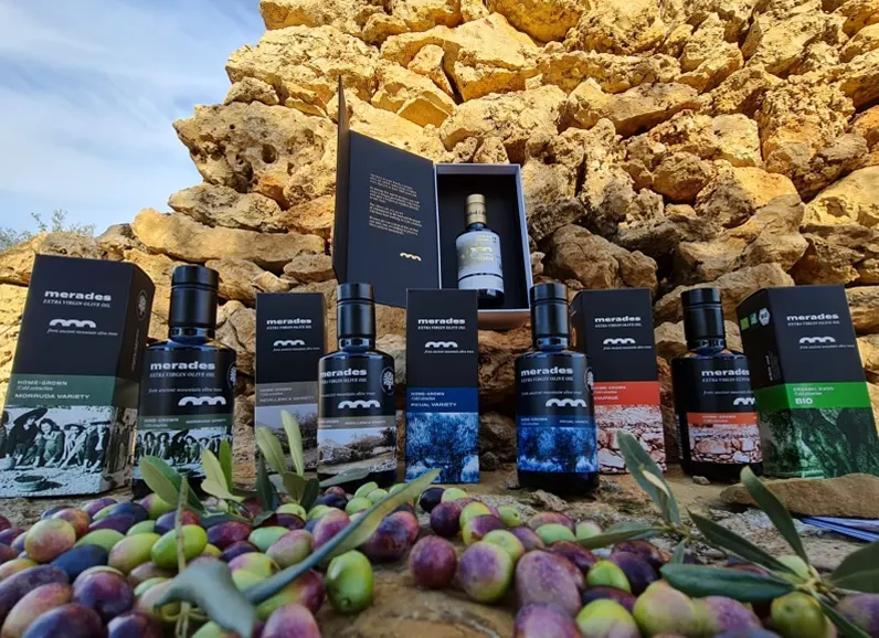 Botellas de aceite Merades sobre un montón de aceituna recién cosechada